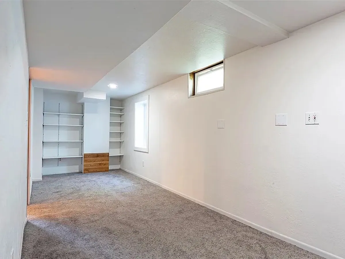 A lower-level den with new carpet run wall to wall after a full remodel