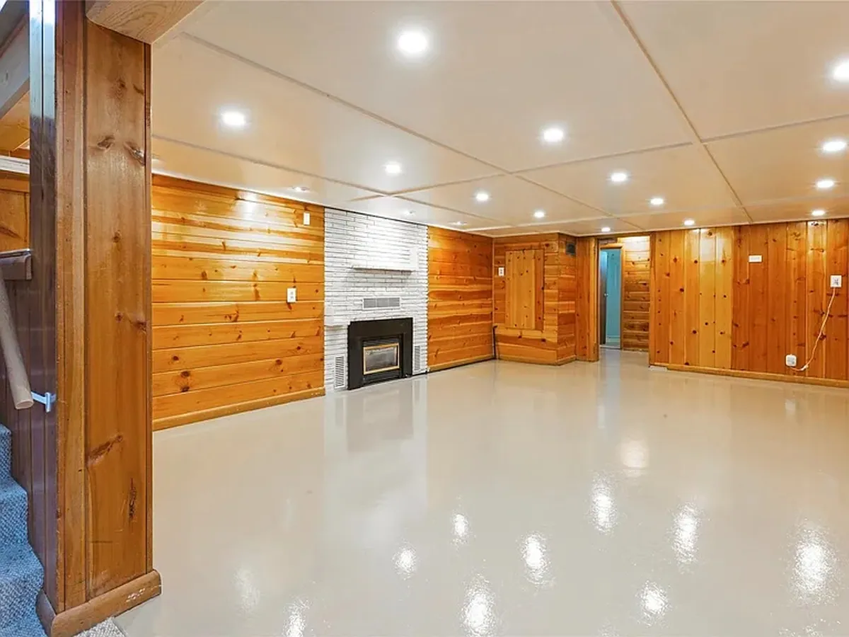 A cured, high-gloss epoxy floor in a finished basement living room